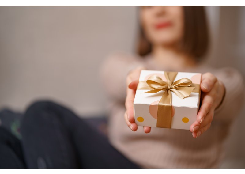 woman-hands-holding-wrapped-white-box-with-golden-bow-focus-box-941-800x568.jpg